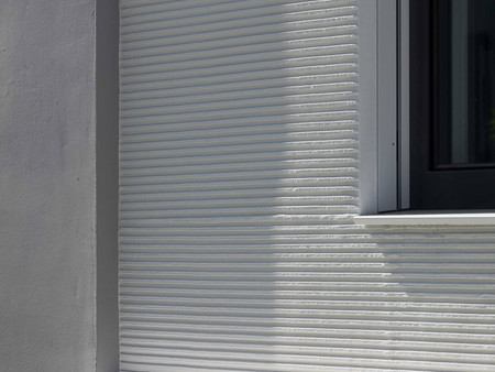 Neubau-Fassade mit langlebigem ThermoSan NGQ Anstrich und vertieften Fensterumrandungen, realisiert mit Kammzug-Technik.
